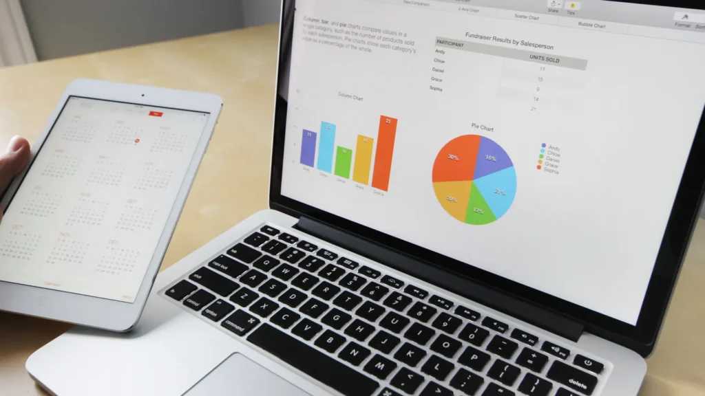 Laptop showing bar and pie charts next to a tablet, representing data-led stories